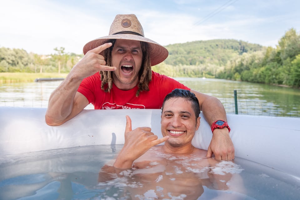 Daniel Fetz und ein Teilnehmer zeigen im Eisbad das Shaka-Zeichen