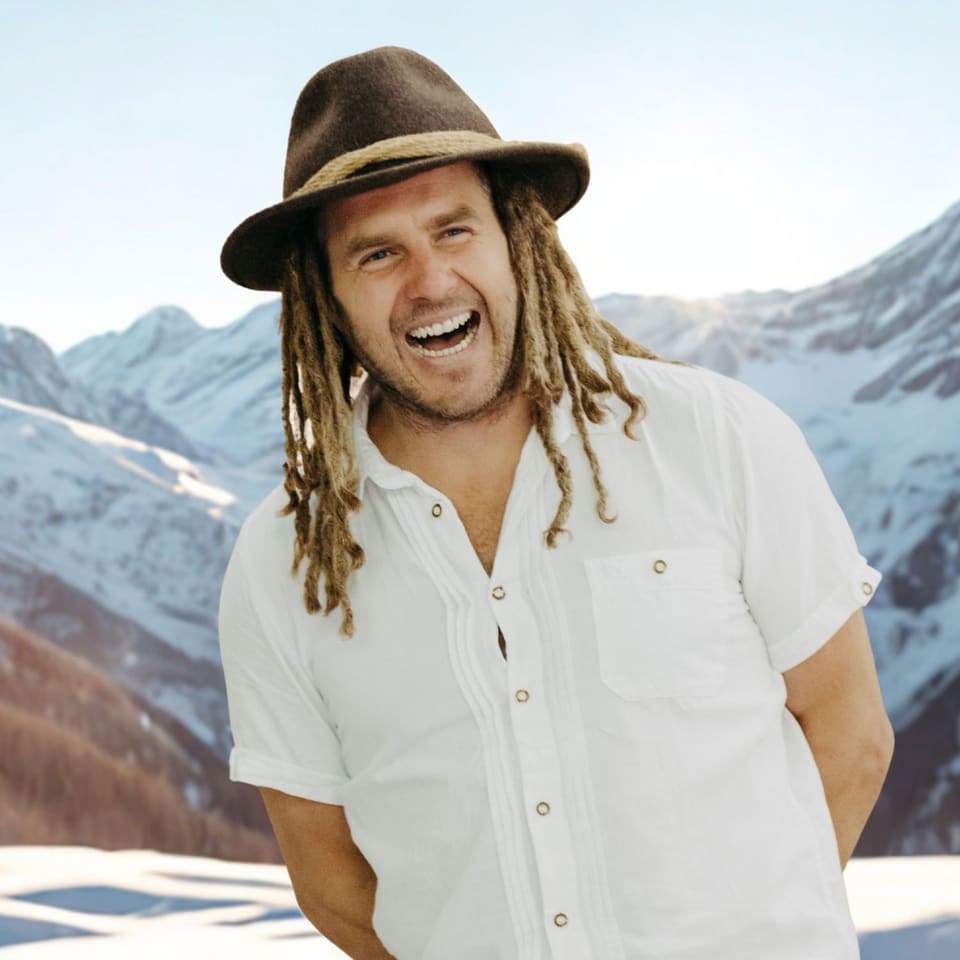 Daniel Fetzy Fetz lacht vor verschneiten Bergen