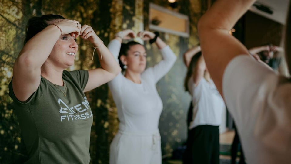 Teilnehmerinnen üben gemeinsam im Stehen