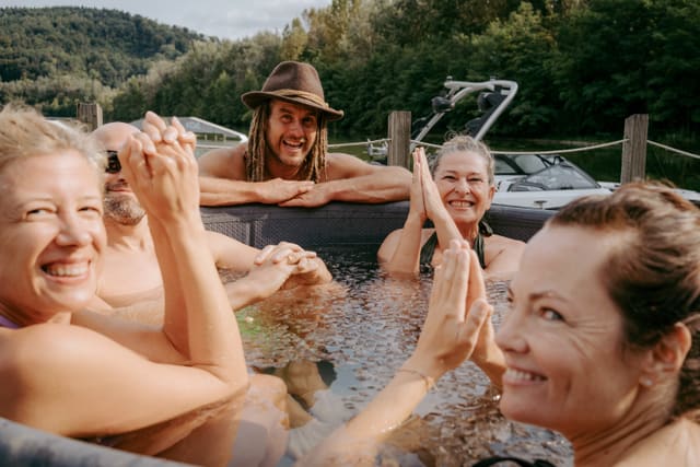 Lachende Frauen und Männer gemeinsam in einer Eistonne