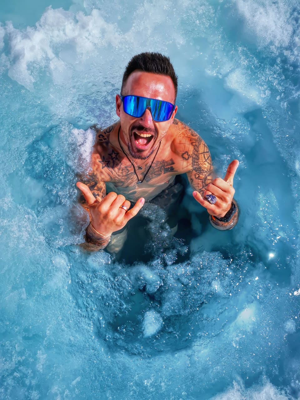 Andreas steht im Pitztaler Gletschereis und zeigt mit beiden Händen das Shaka-Zeichen