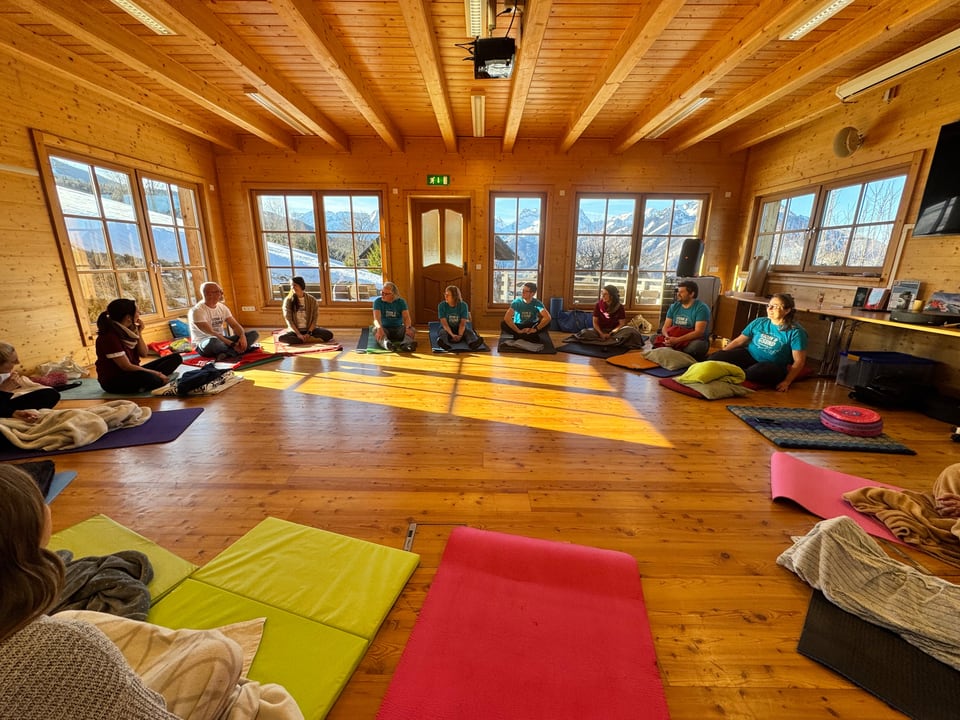 Retreatgruppe bei einer Atemfitness Einheit im hellen Holzchalet