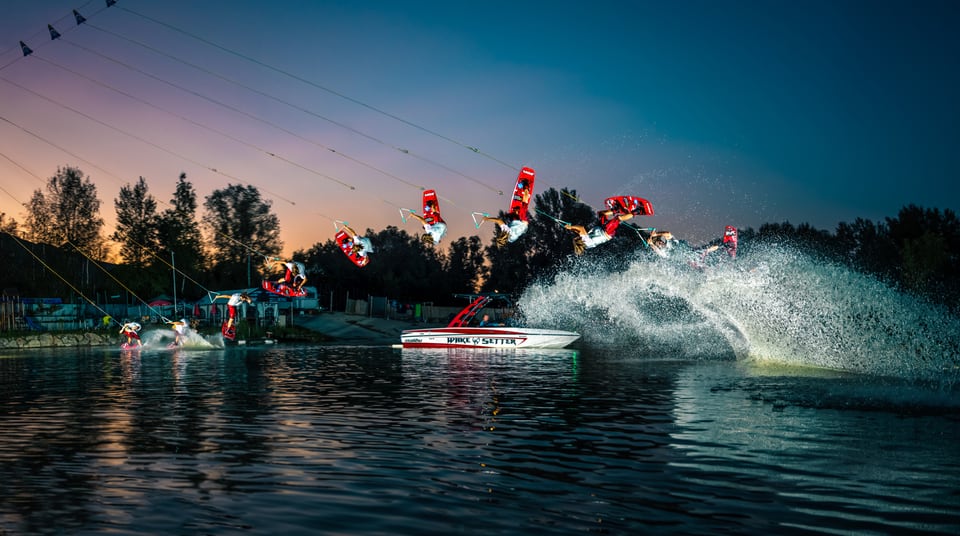 Daniel Fetzy Fetz zeigt eine Wakeboard-Sequenz hinter einem Boot in der Abenddämmerung
